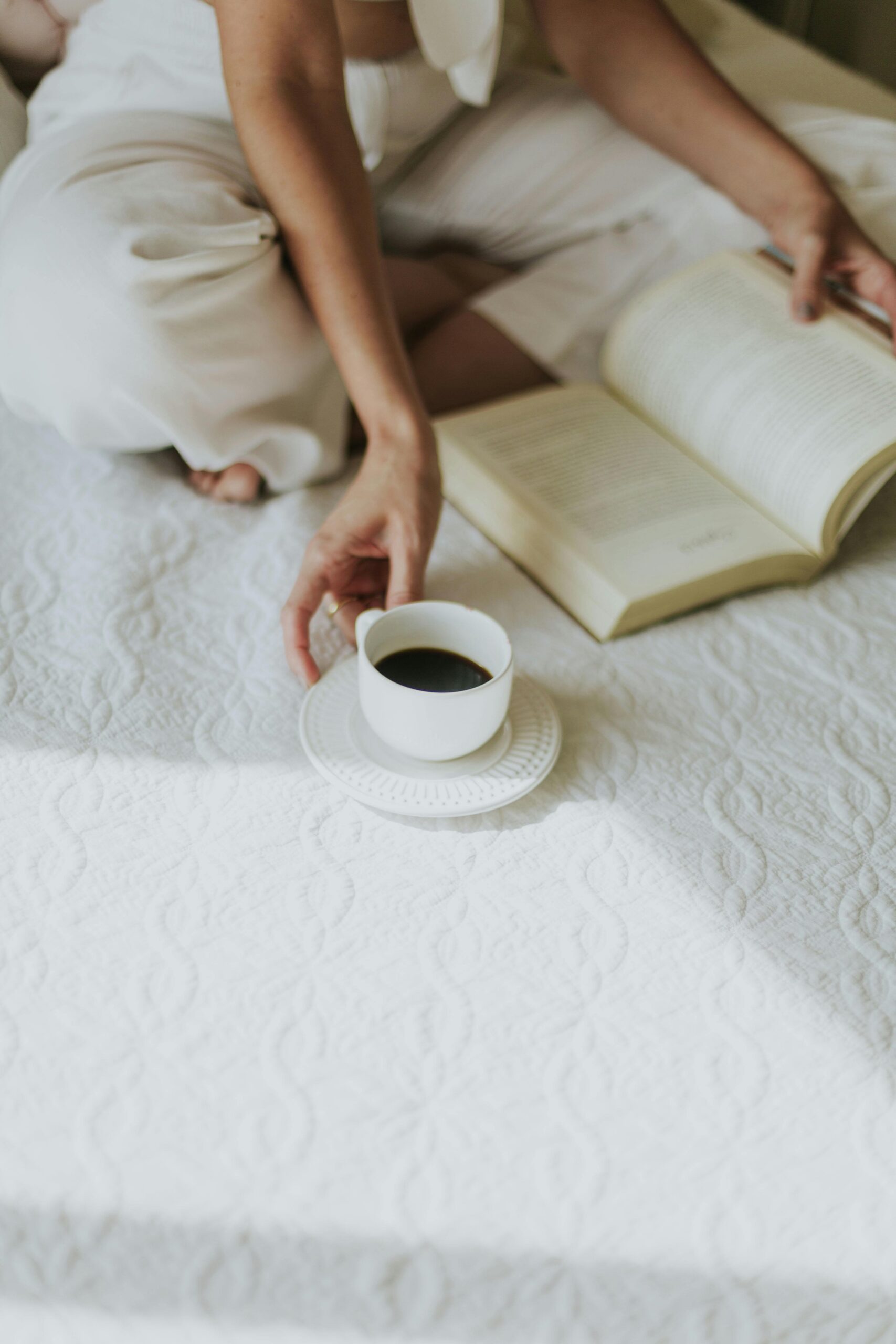 A woman sitting peacefully with a journal and pen in hand, surrounded by natural light and cozy textures—capturing a quiet moment of reflection and clarity.