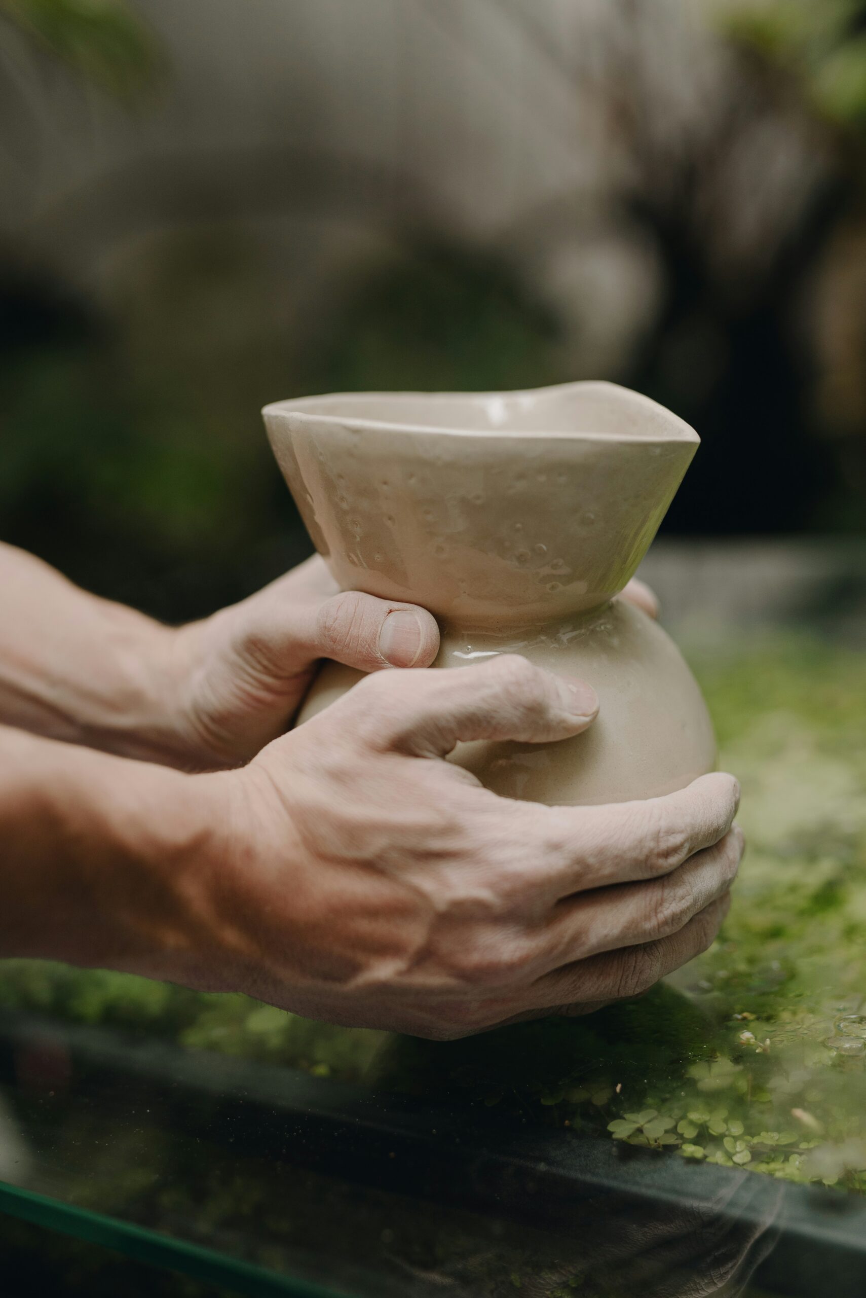 Hands gently holding a handmade clay vessel, symbolizing a life restored for His glory through healing and grace.