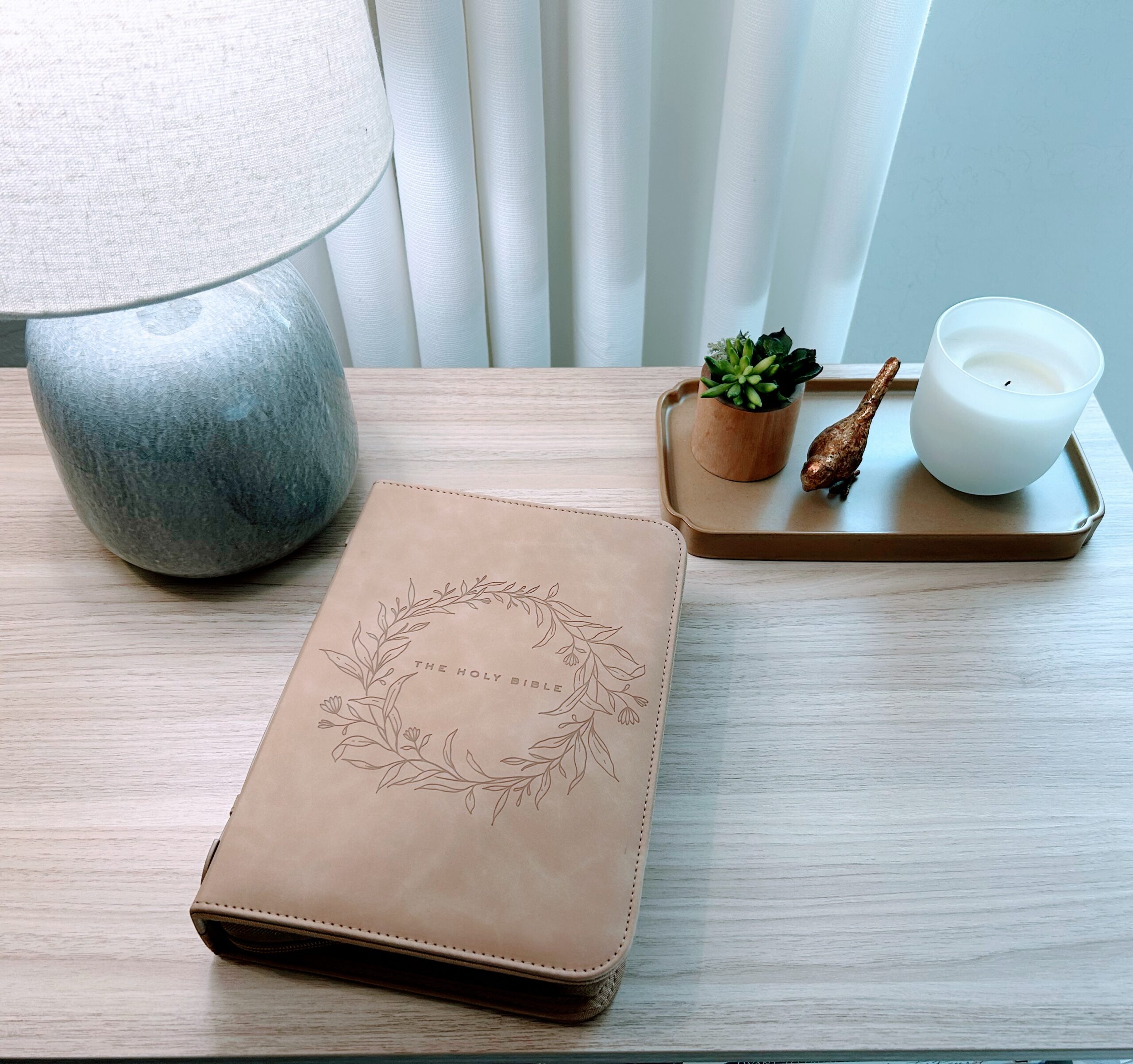 Quiet time tools – Bible case on a peaceful desk with a lamp, candle, and plant.