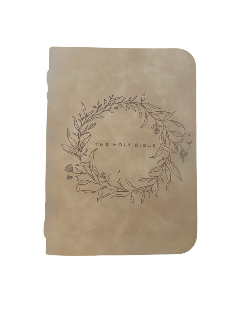 Tan faux leather Bible case with floral wreath design and the words “The Holy Bible” in the center.